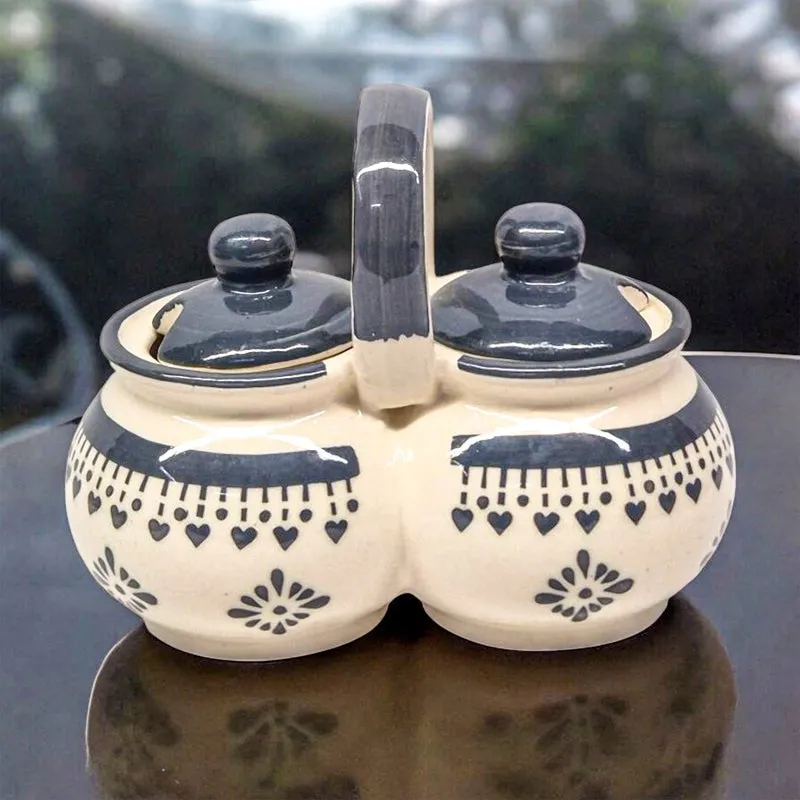 Closed blue and white ceramic condiment jar displayed on a dark reflective surface.