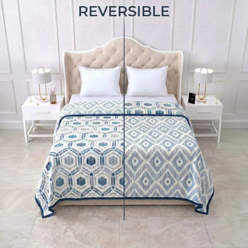 Reversible blue and off-white dohar showing both sides on a bed