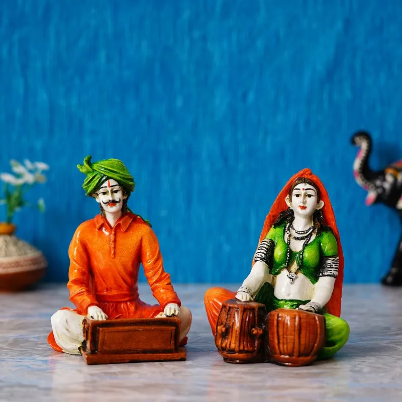 Two multicolour seated musician showpieces against a blue backdrop