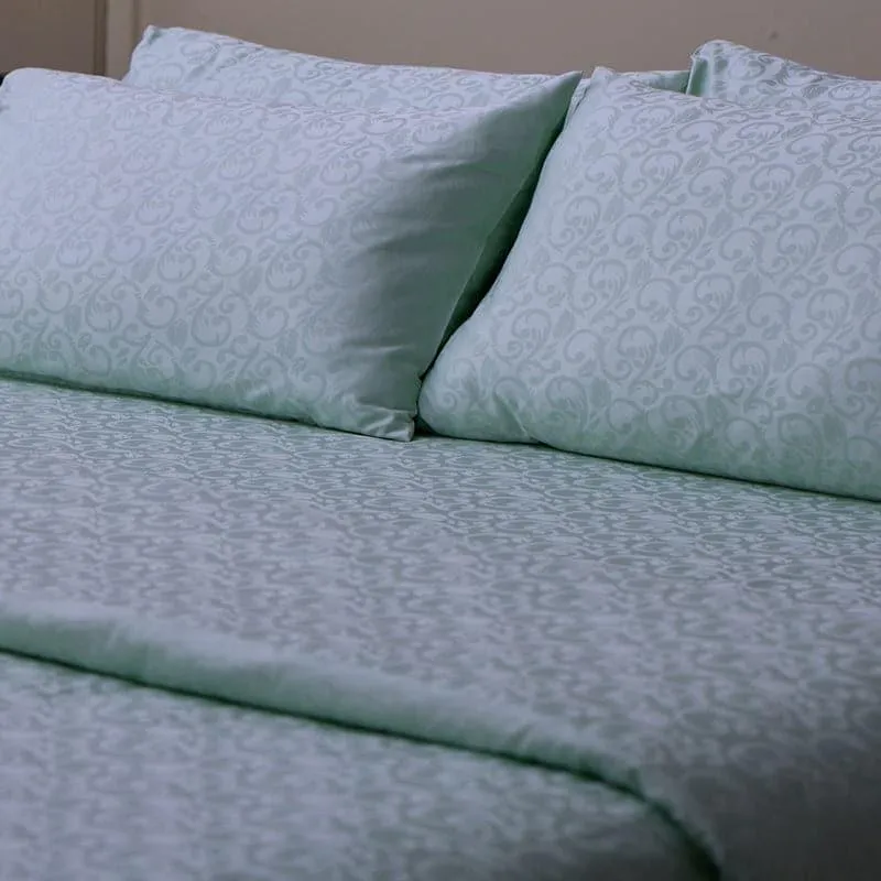 Close-up of ice blue pillow covers and bedsheet with damask pattern
