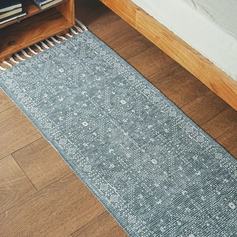 Close view of blue patterned runner rug placed beside a bed