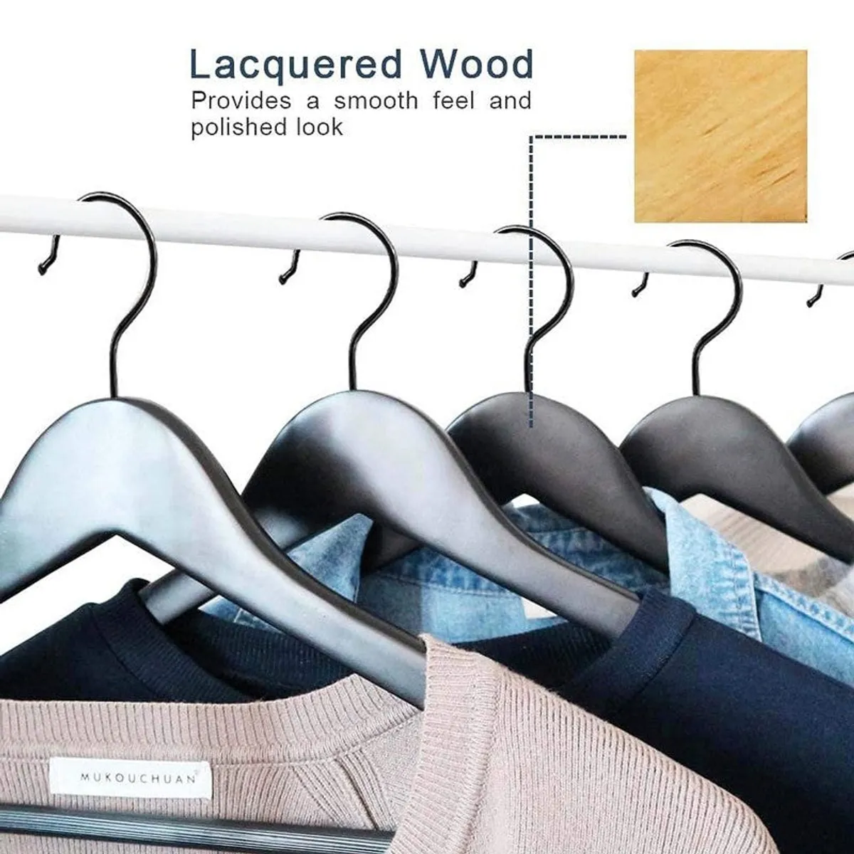 Black wooden hangers hanging on a rail with folded garments