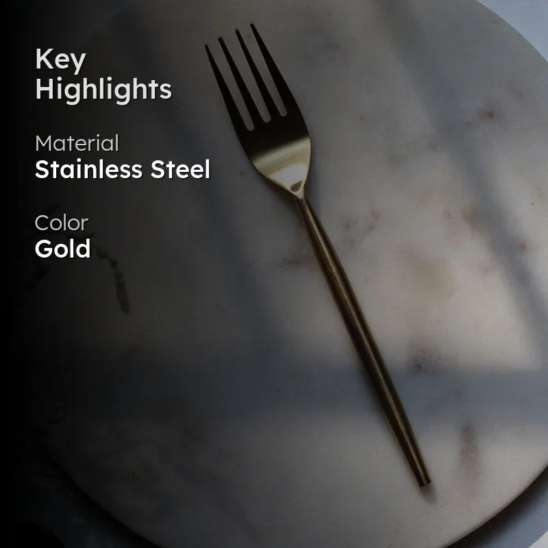 Gold fork with slim handle on a white surface