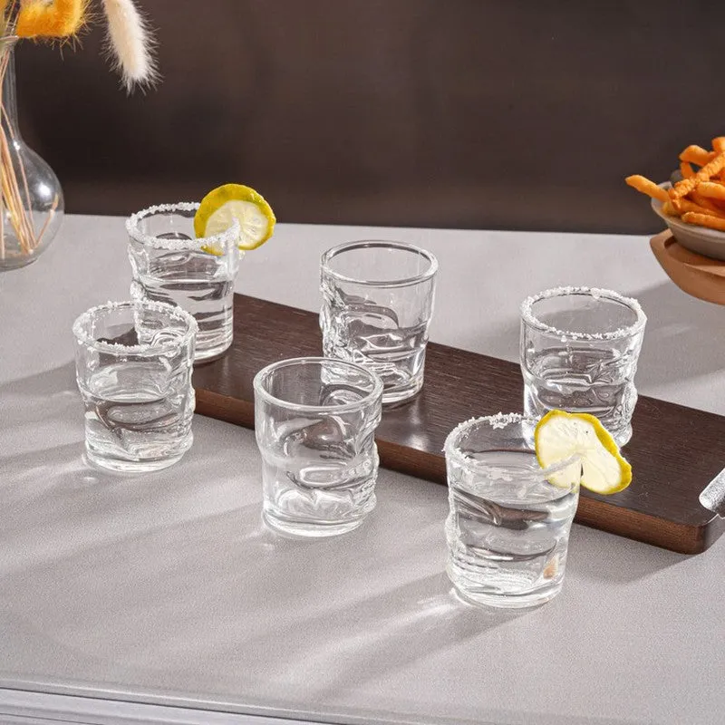 Clear skull-shaped shot glasses filled and served with lemon slices