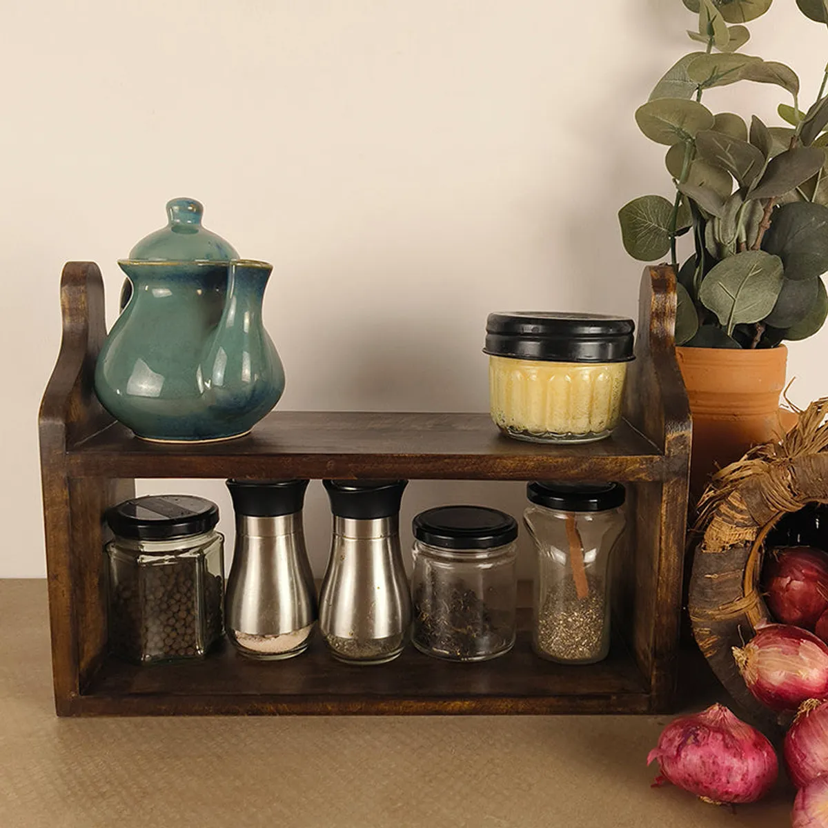 Brown wooden two-tier kitchen stand styled with jars and a teapot
