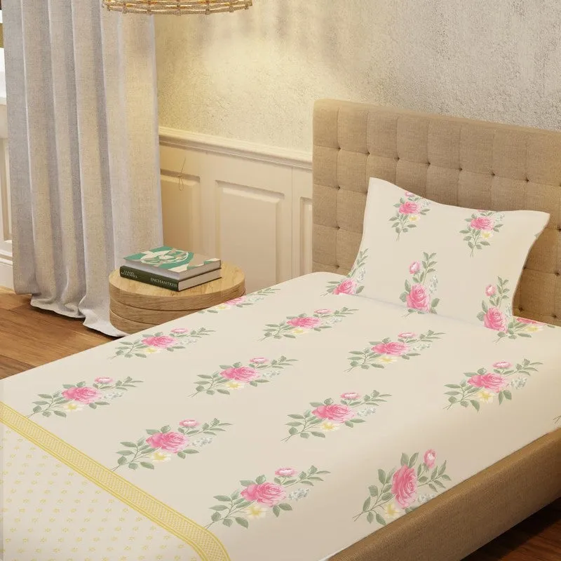 Close view of off-white bedsheet with pink floral motifs and matching pillow cover