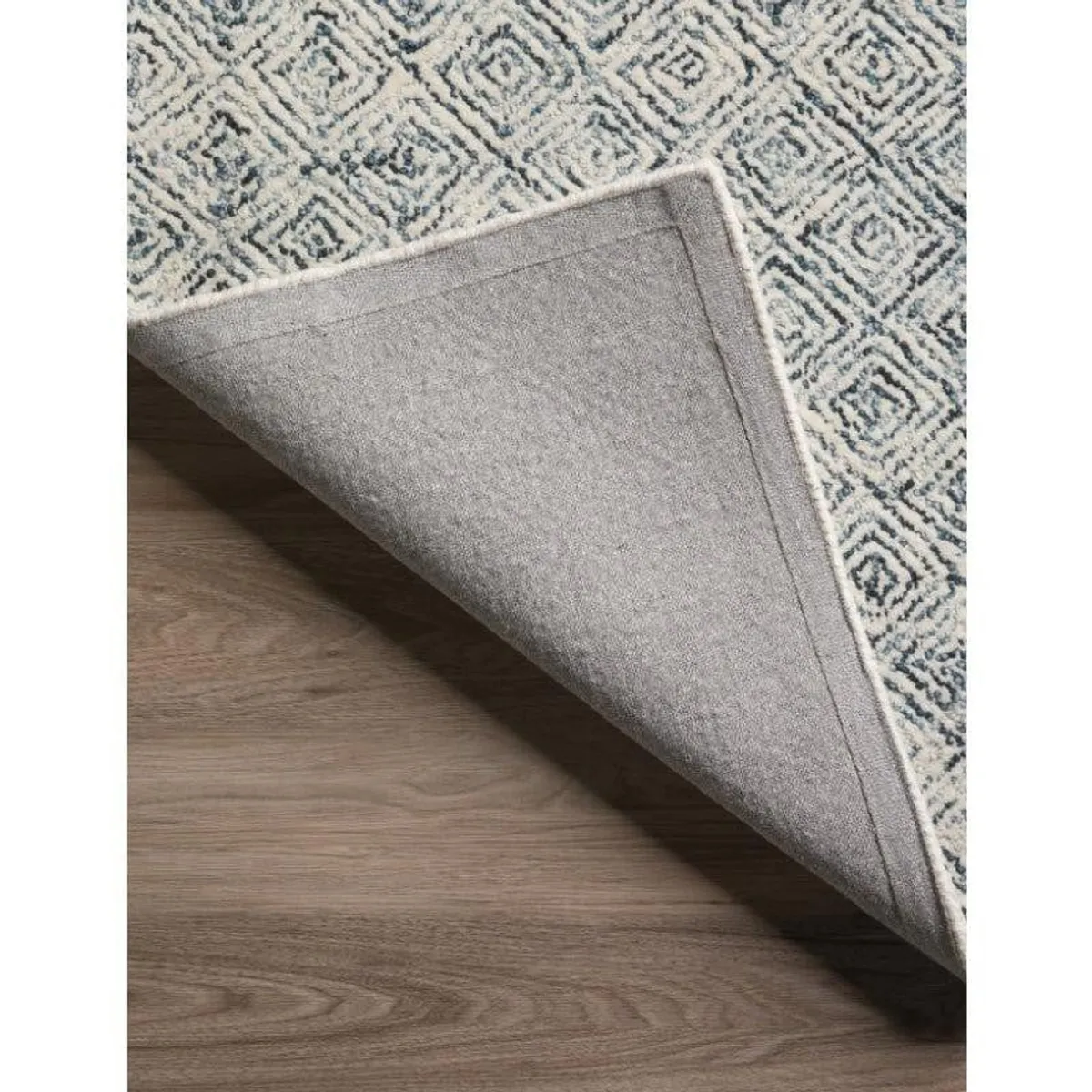 Underside of the rectangular rug showing its plain backing