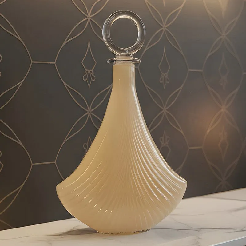 Ivory glass vase with clear ring stopper on a tabletop
