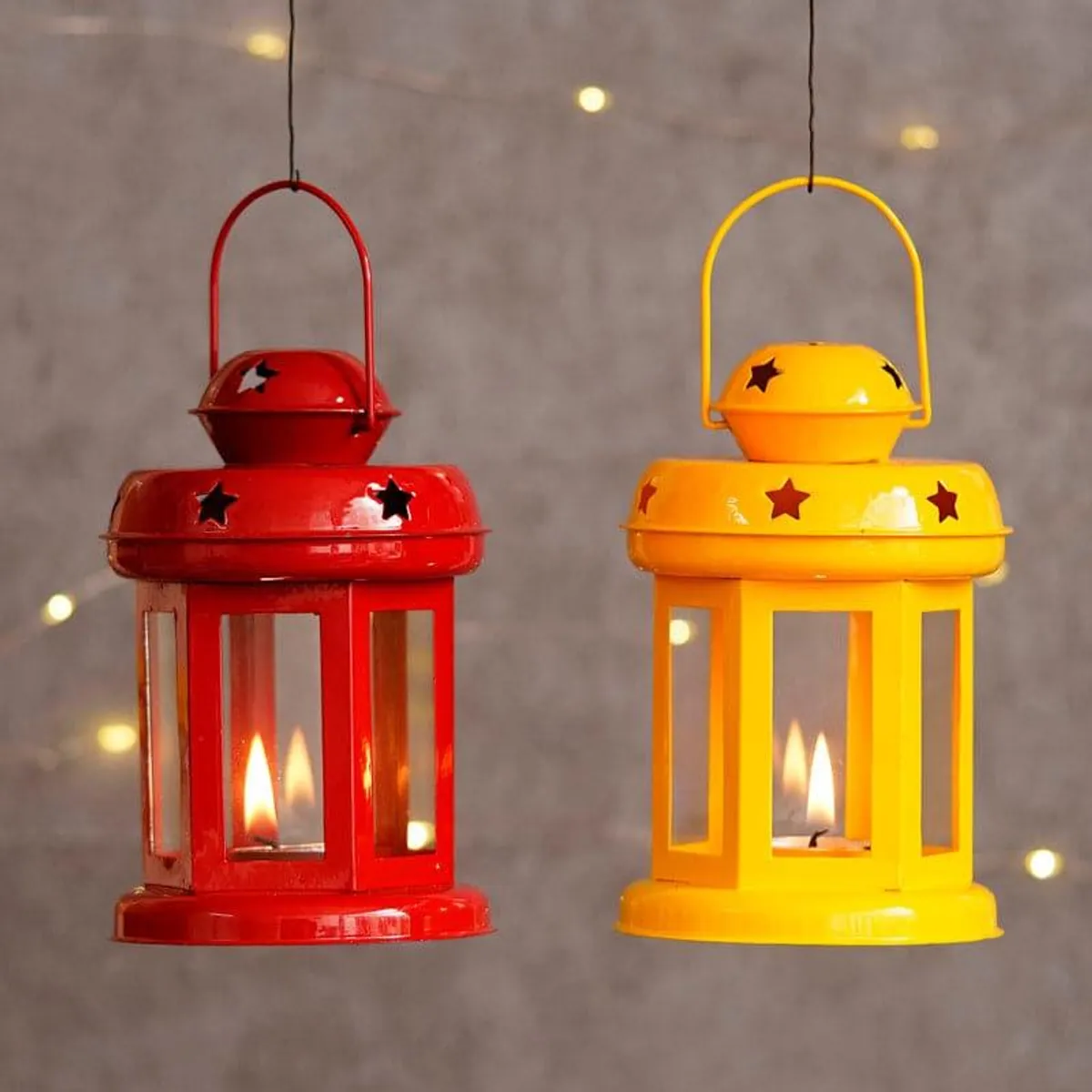 Red and yellow lantern-style tealight candle holders hanging side by side