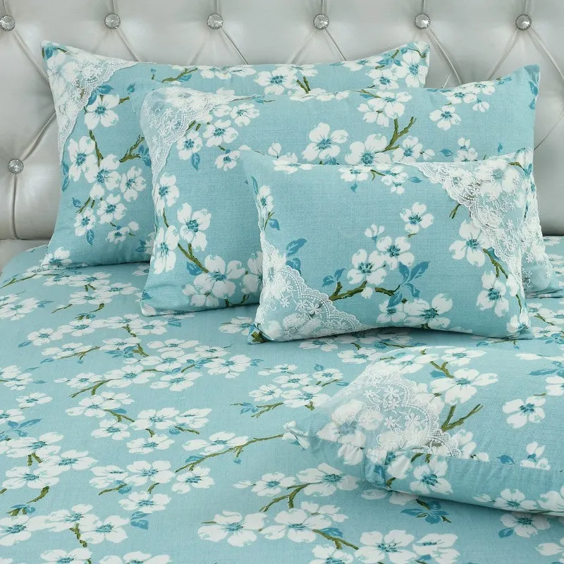 Close-up of matching blue floral pillow and cushion covers with white lace detail