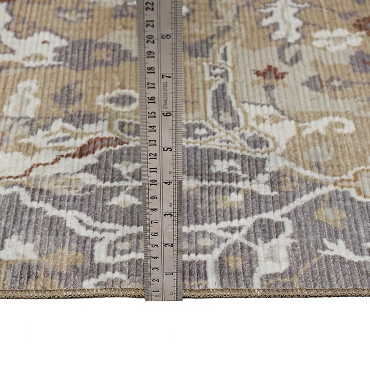 Close-up of carpet edge with ruler placed vertically beside it