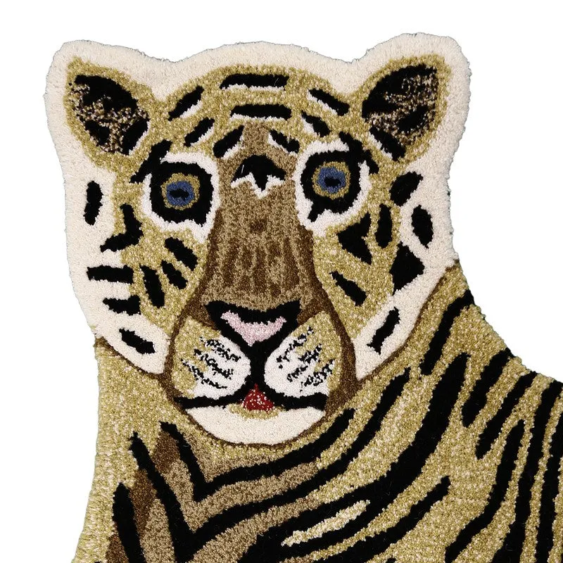 Close-up of the tiger carpet's face with black stripes and blue eyes