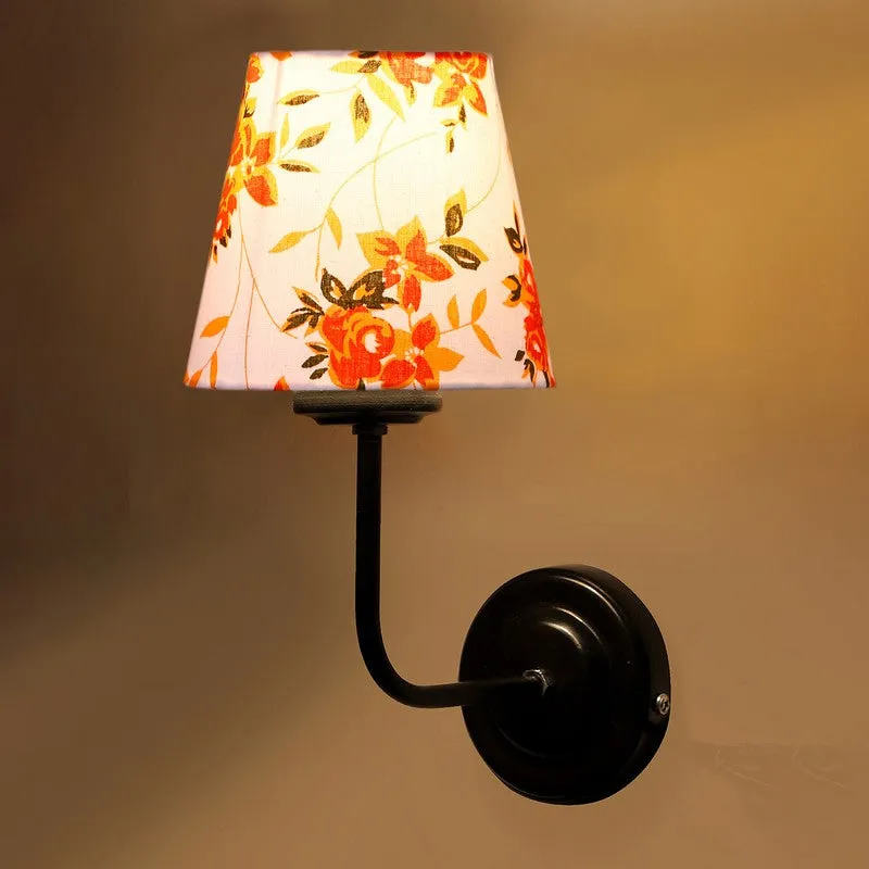 Close-up of lit floral cone shade wall lamp with black iron mount