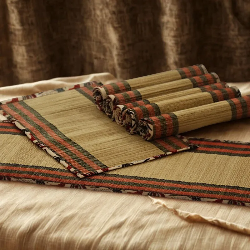 Stack of rectangular bamboo table mats with striped fabric borders