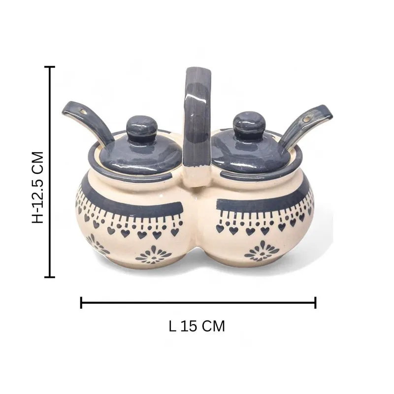 Blue and white ceramic dual condiment jar with lids placed beside it.