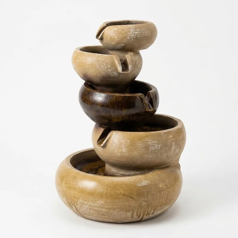 Close-up of a sculptural beige and brown tabletop water fountain