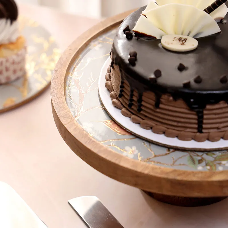 Close view of the grey floral cake stand surface and wood rim