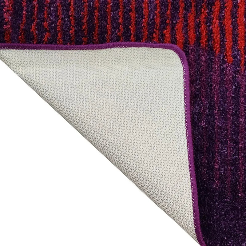 Underside of the purple rug showing its light patterned backing