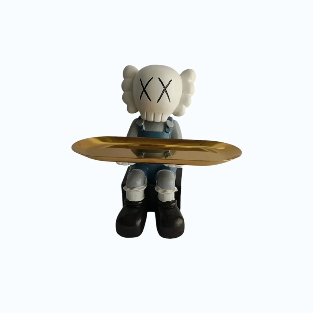 Cartoon figurine and gold tray shown against a light background