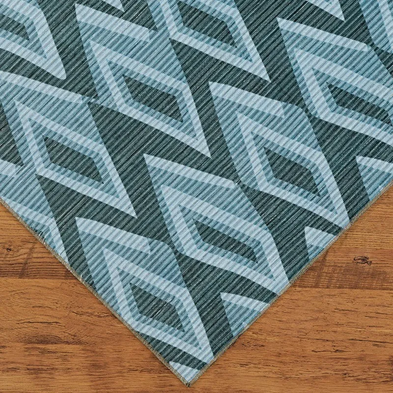 Corner view of blue geometric carpet on wooden floor