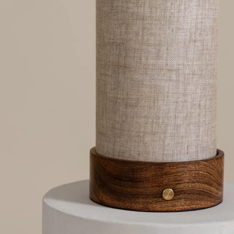 Close-up of the beige shade and wooden base with brass button