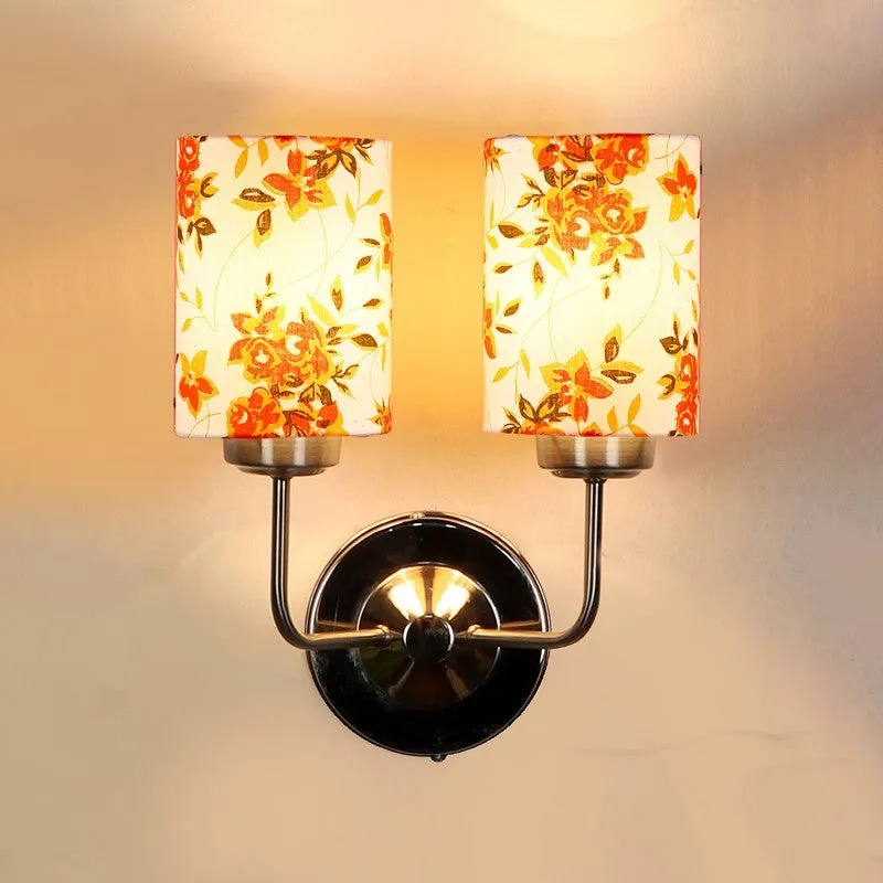 Front view of illuminated dual-shade floral wall lamp