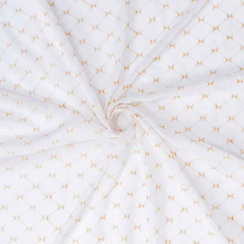 Close-up of white sheer curtain fabric with a gold geometric pattern