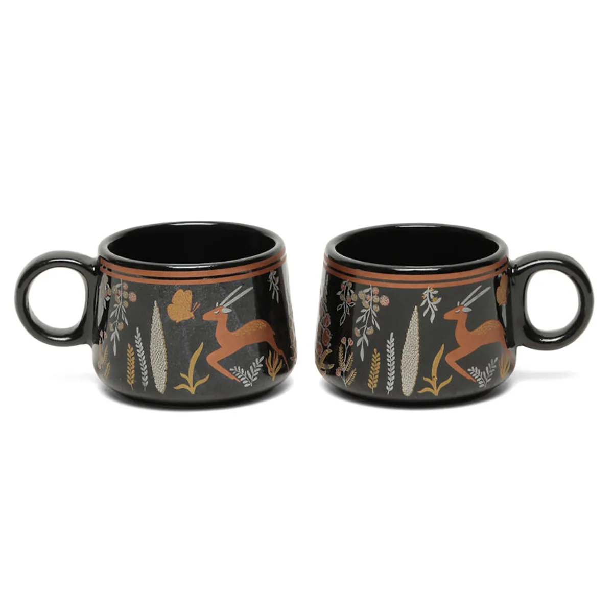 Two black ceramic tea cups with wildlife motifs displayed side by side