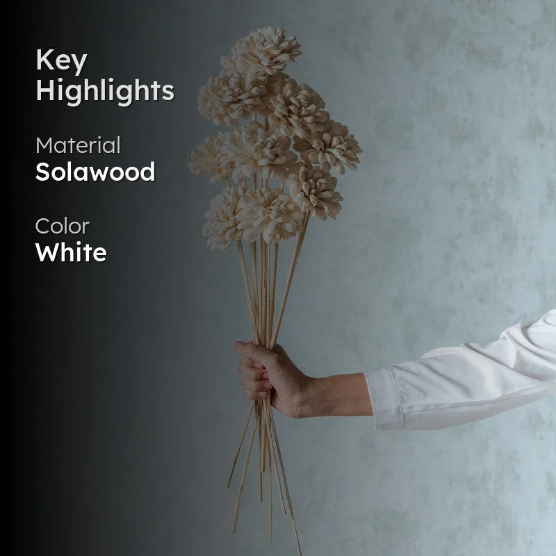 White flower stick arrangement shown against a soft blue backdrop
