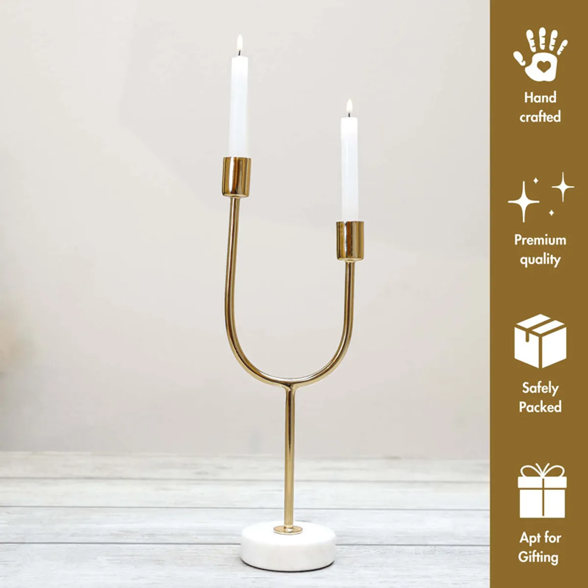 Gold U-shaped candle holder with white round base against a plain backdrop