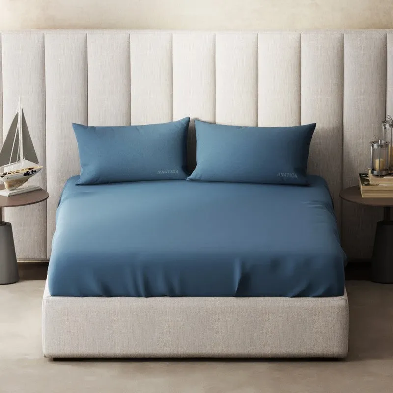 Front view of blue solid bedsheet set on an upholstered bed