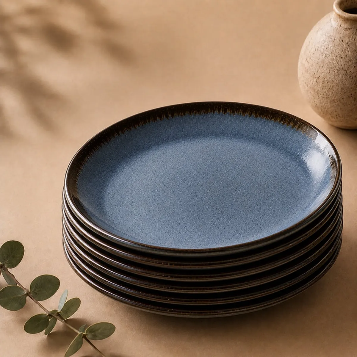 Stack of glossy deep blue dinner plates with dark rims