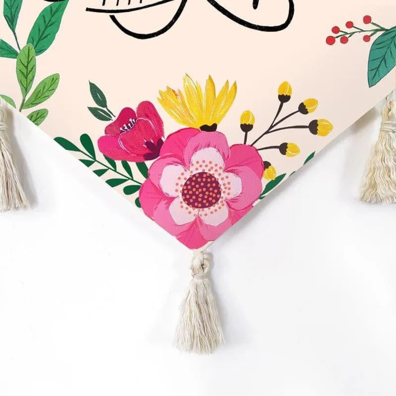 Close-up of floral print and tassel detail on the pointed canvas wall hanging