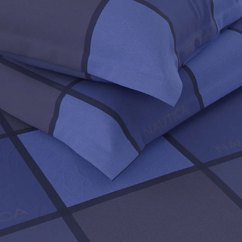 Close-up showing the blue checked bedsheet's fabric texture