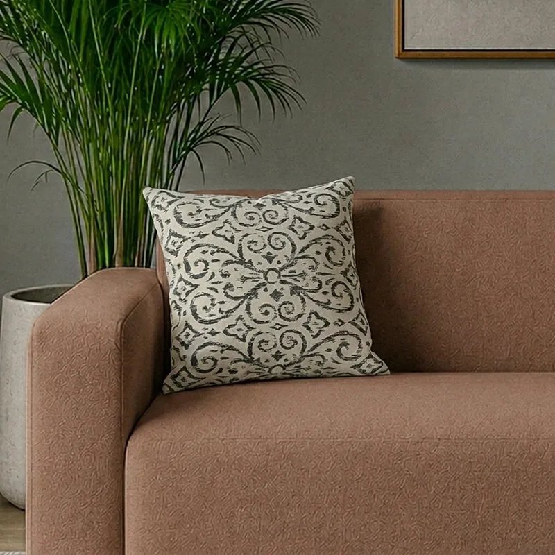 Printed square cushion cover placed on a brown sofa