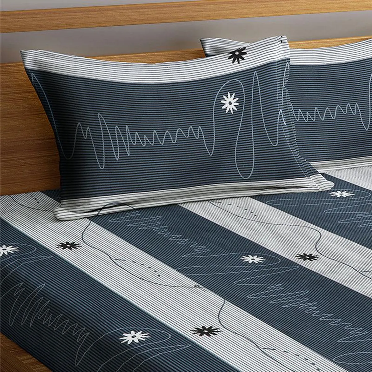 Matching blue and grey pillow cover and striped bedsheet with star motifs
