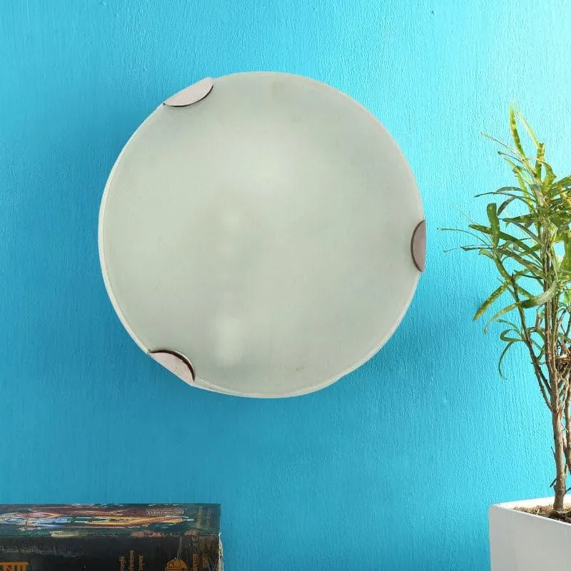 Round frosted glass wall lamp unlit on a blue wall