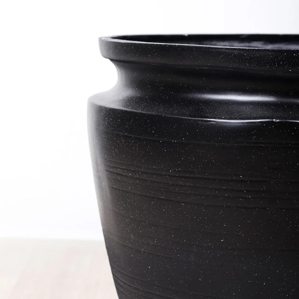 Close-up of the planter's black textured surface and wide rim