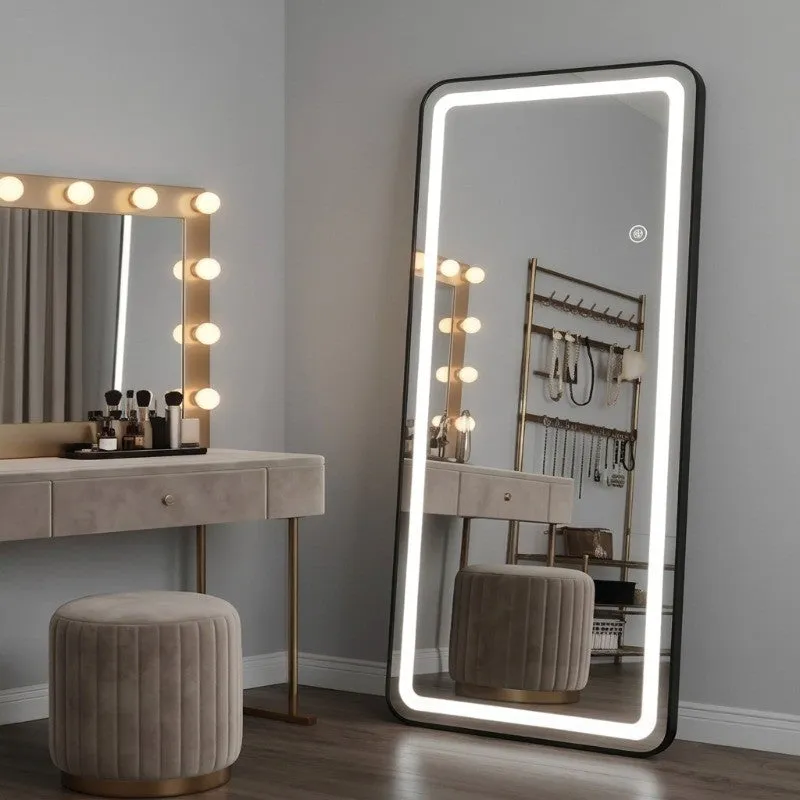 Full-length LED mirror with bright border beside a dressing table.
