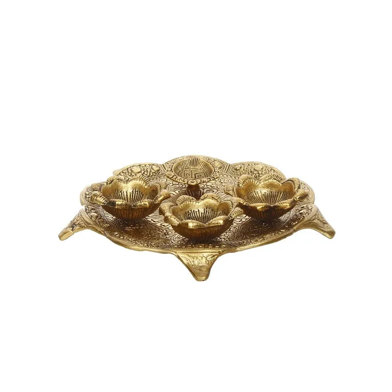Angled view of gold pooja thali with four raised holders and intricate detailing