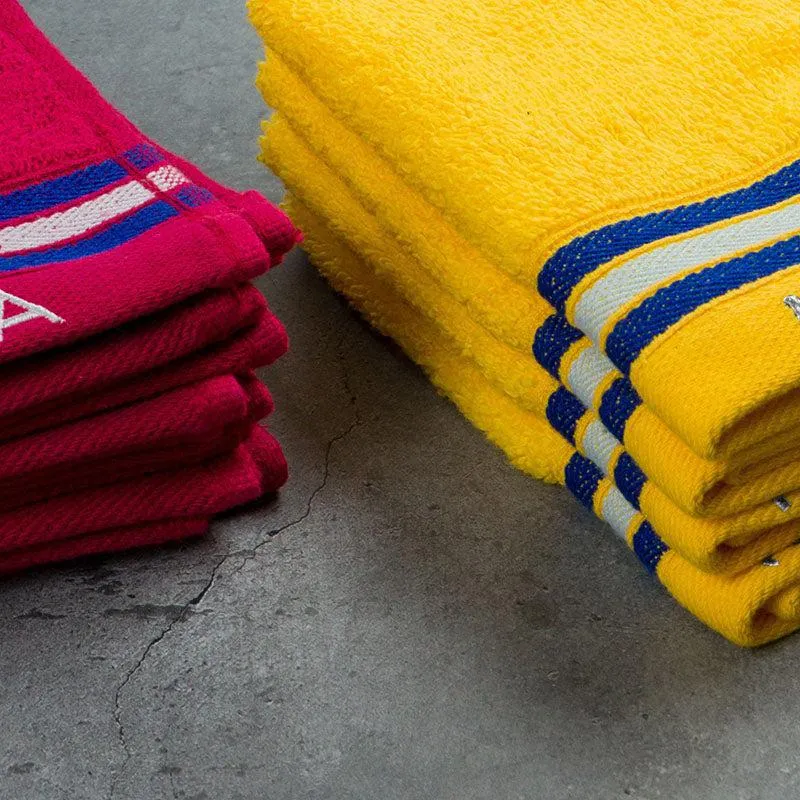 Close-up of folded burgundy and yellow towels with striped edges