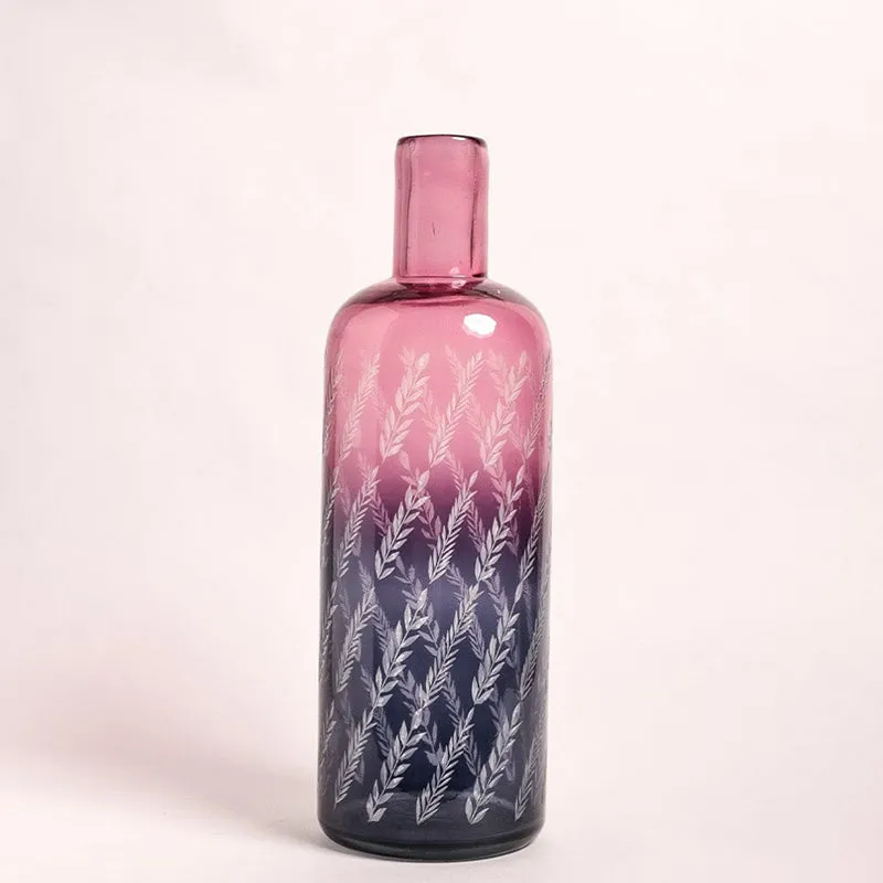 Front view of a pink gradient glass bottle vase with etched leaves