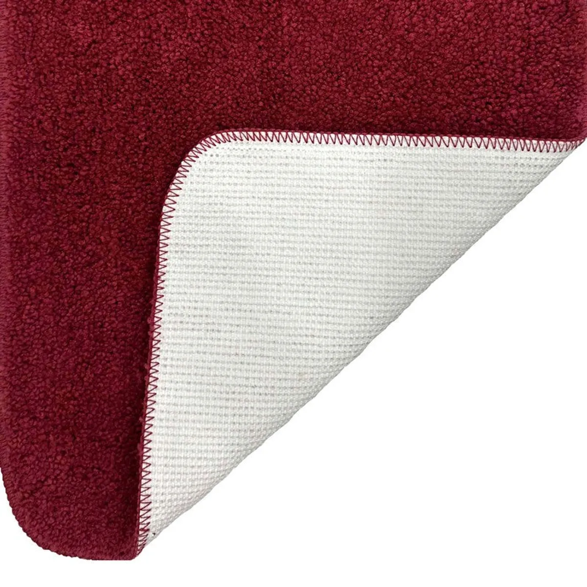 Close-up of the maroon mat corner showing its light-coloured backing
