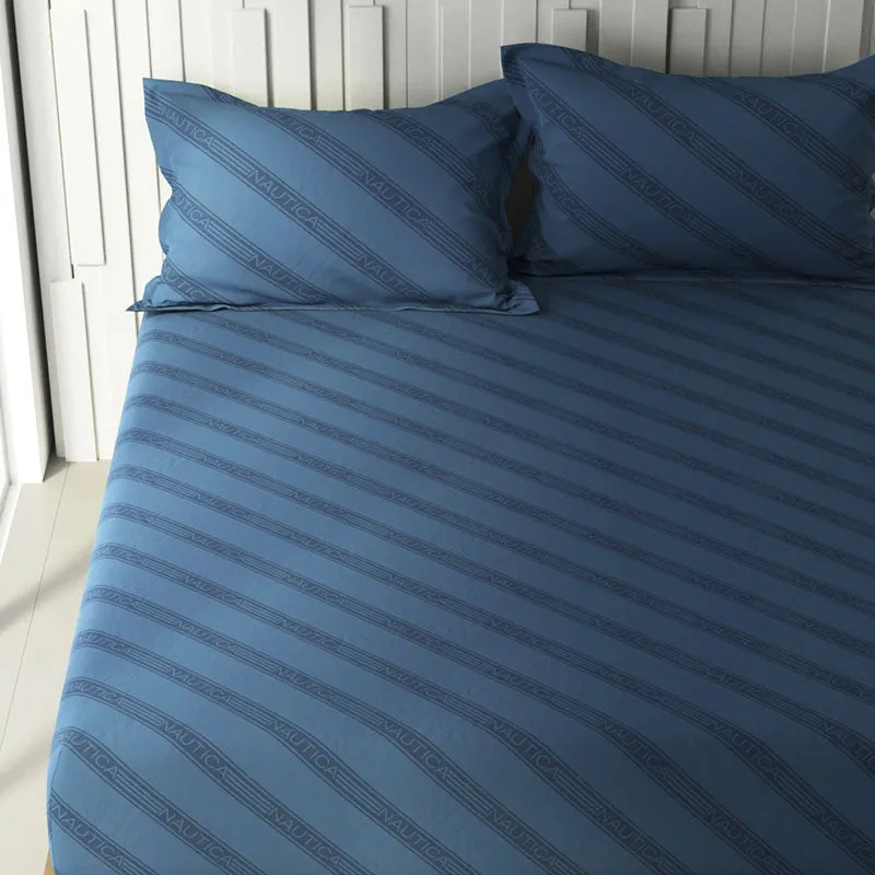 Close view of navy blue bedsheet with diagonal branded stripe pattern