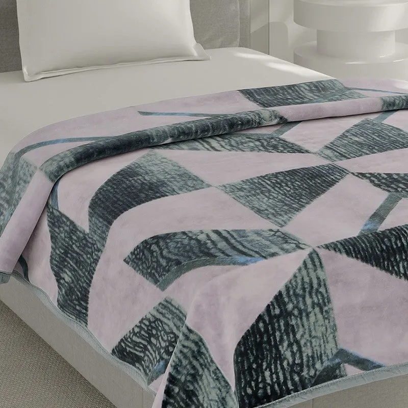 Close view of the blanket's pink and green geometric pattern