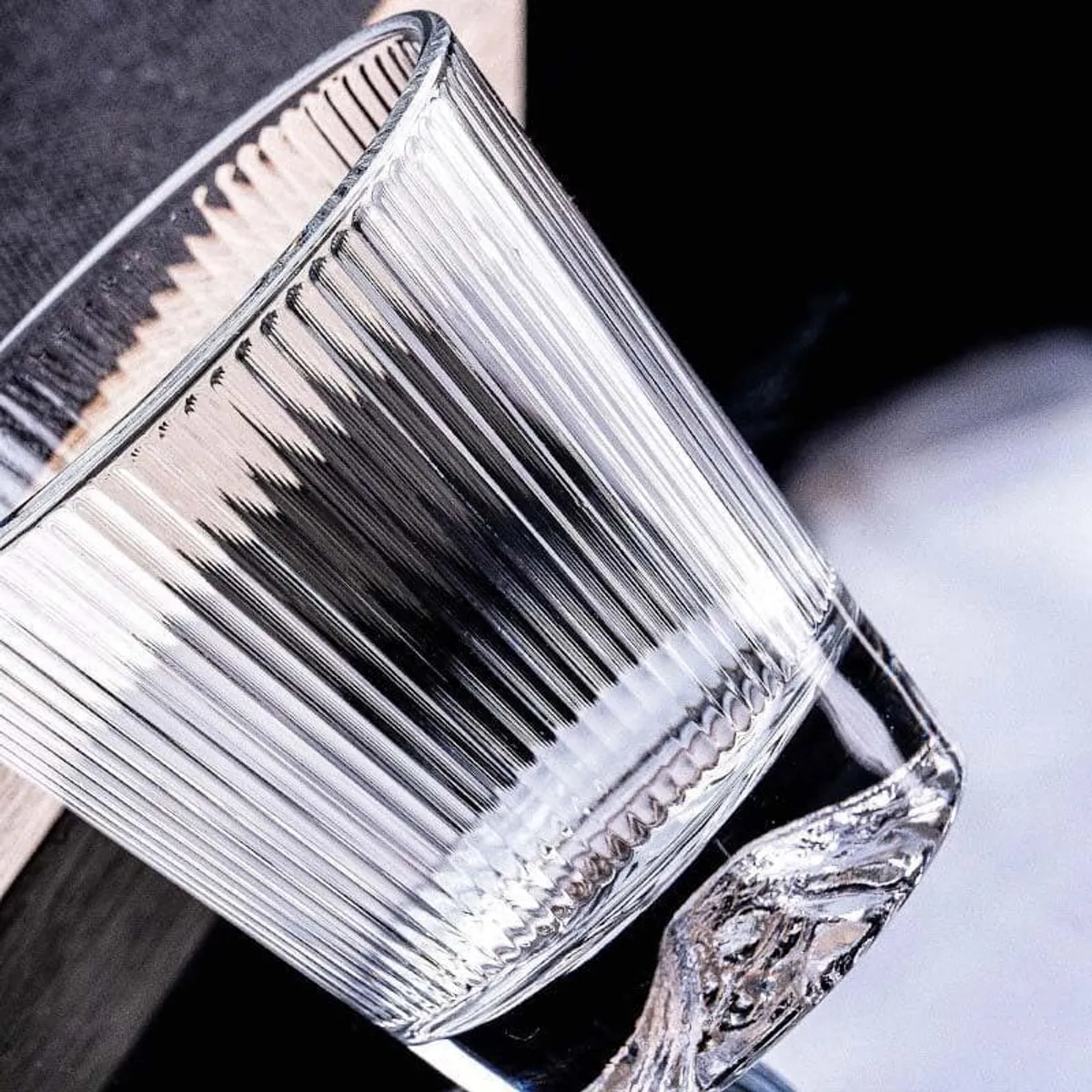 Close-up of a clear vertically ribbed glass with a thick textured base