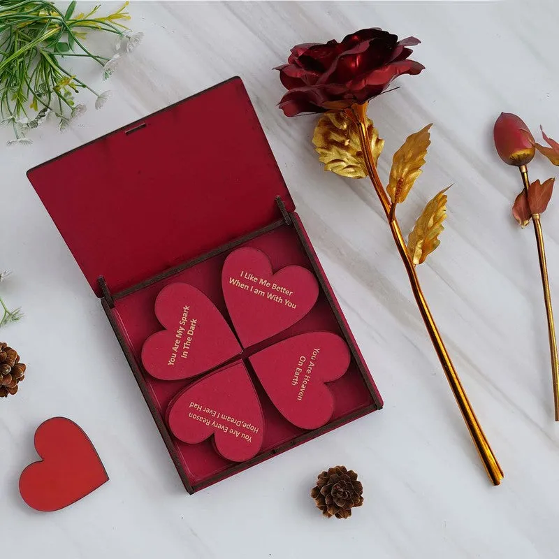 Open red gift box with heart-shaped love notes and a metallic red rose
