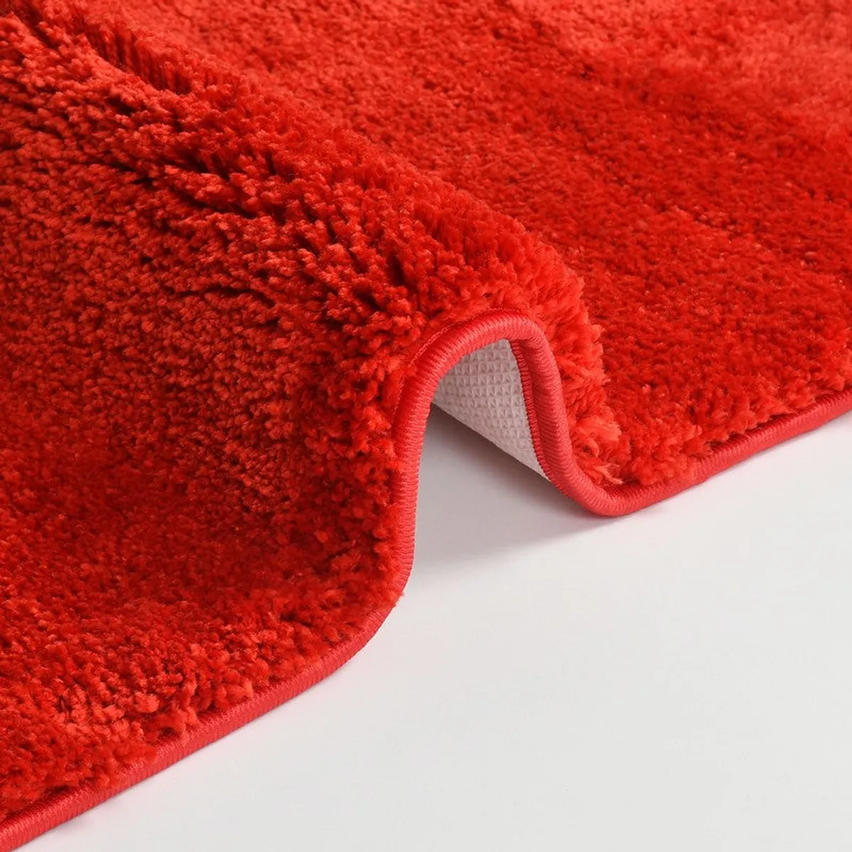 Close-up of red bath mat edge and textured backing