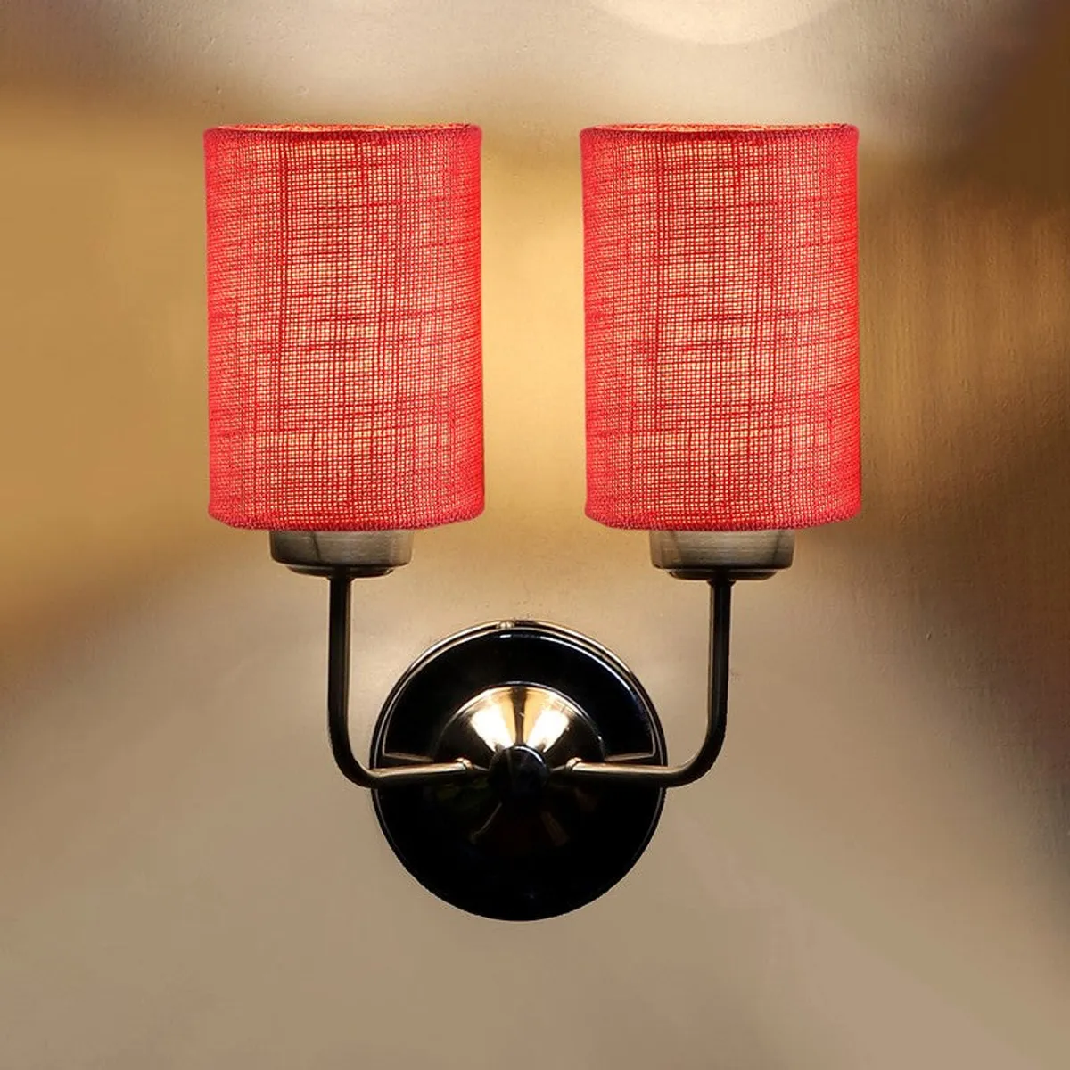 Close view of red double-shade wall lamp lit on wall