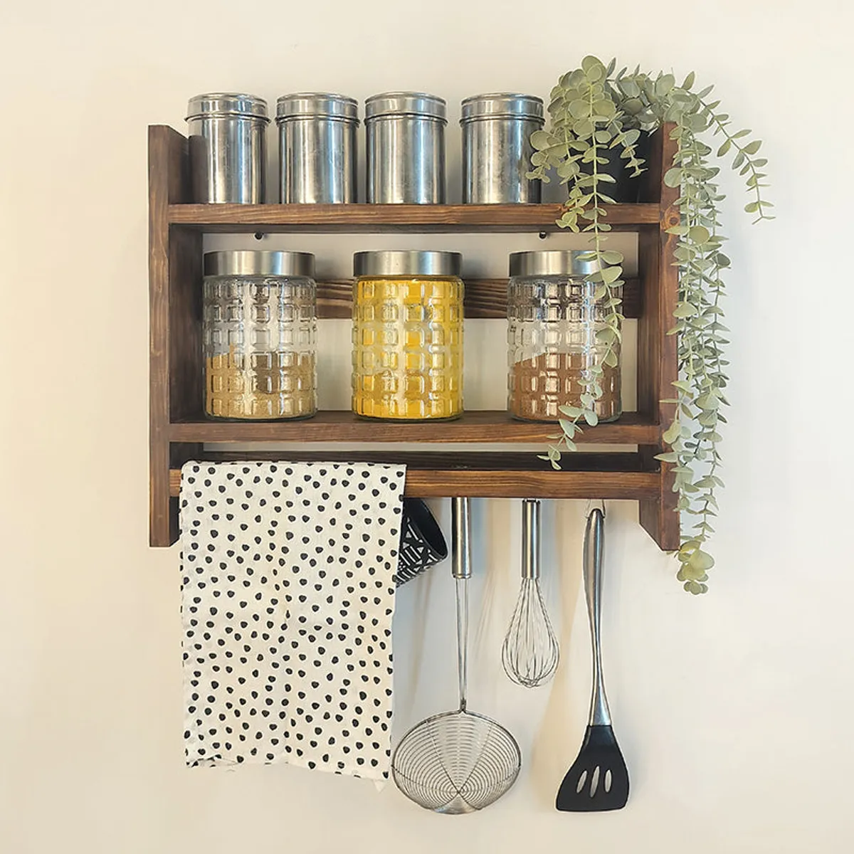 Front view of brown wooden kitchen rack displaying jars and metal containers